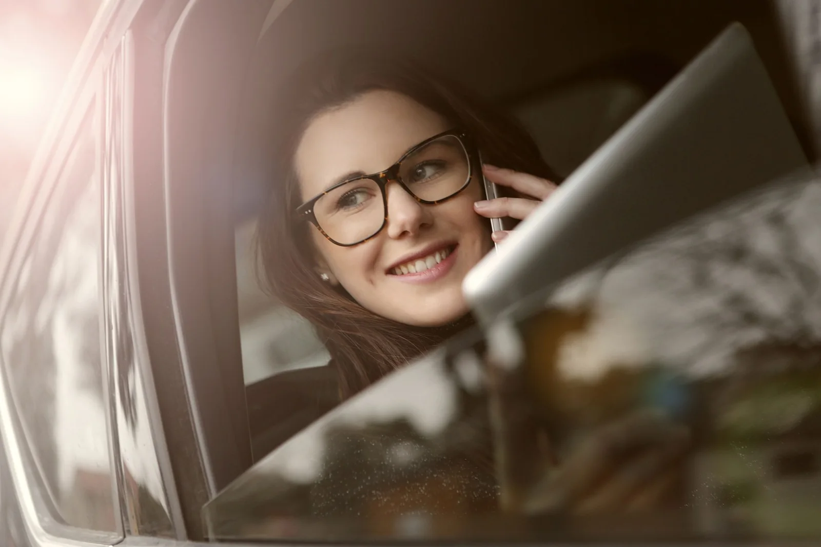 Professional woman having a phone conversation while seated in a car