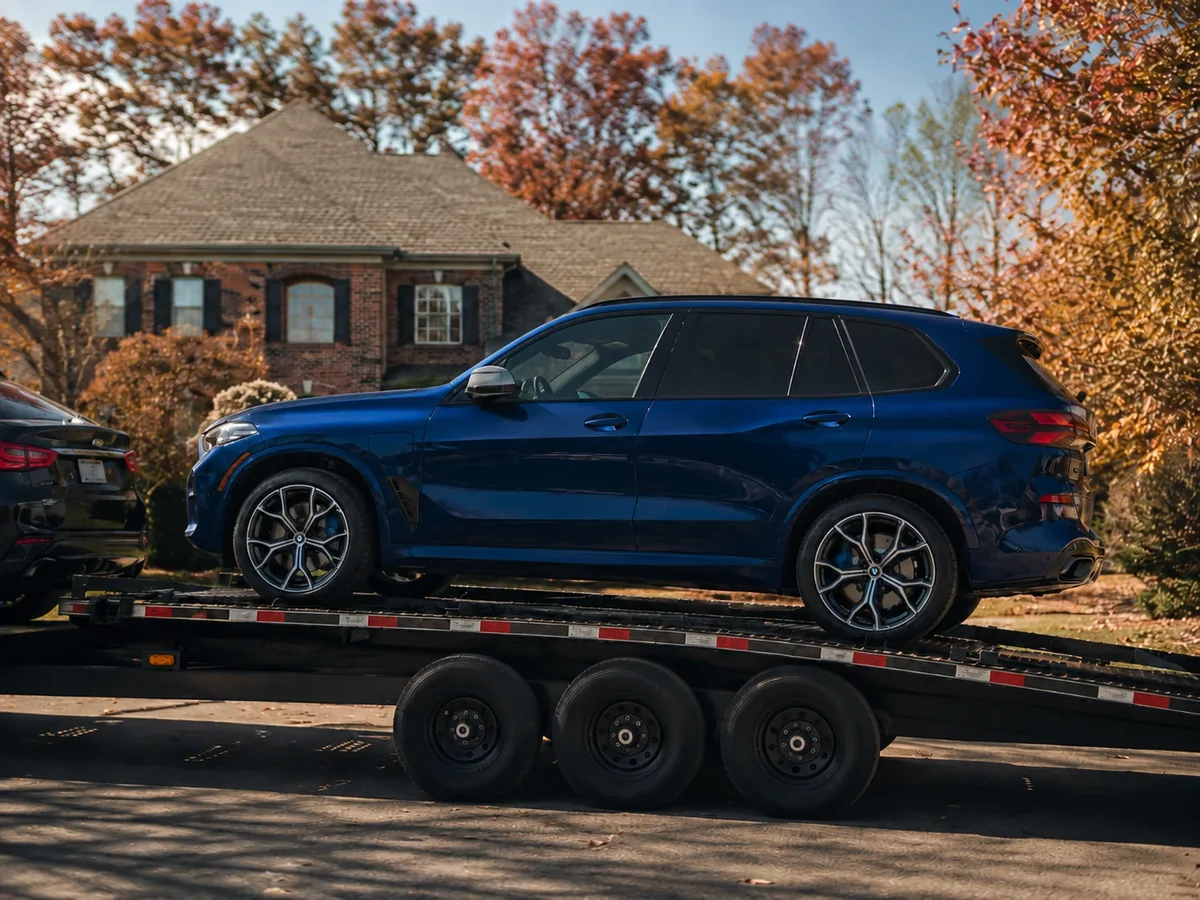 Deep blue BMW X5 arriving on a transport trailer at the client’s home