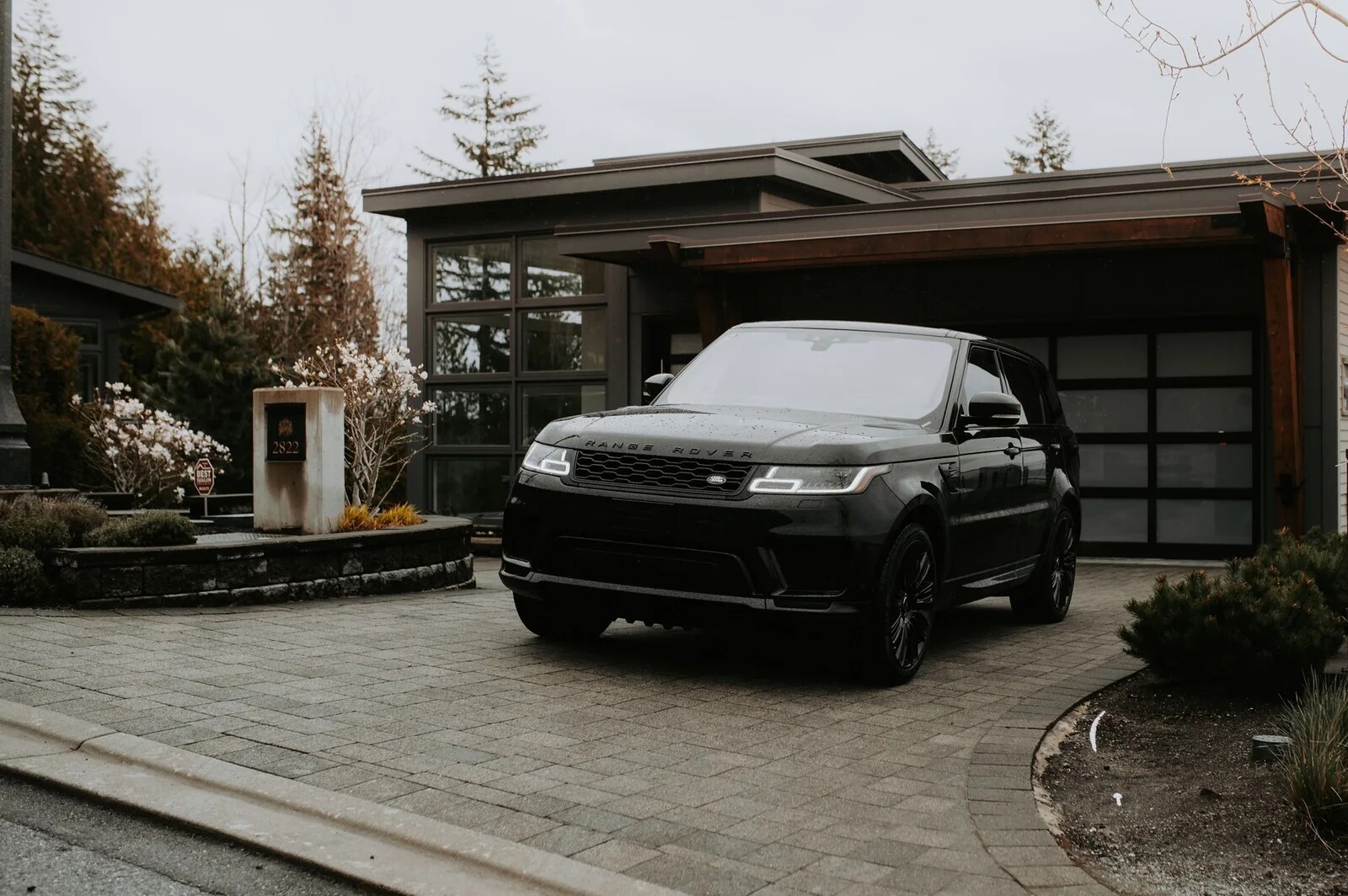 Real black Range Rover parked in the driveway of a modern home